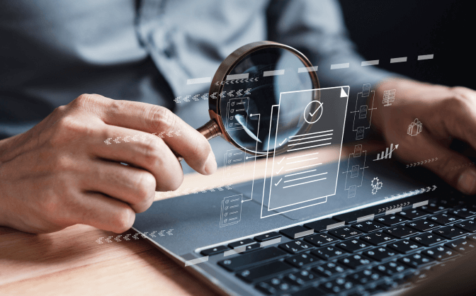 Gravamen a los Movimientos Financieros Imagen de un teclado de computador portátil y una mano sosteniendo una lupa para ver y analizar las métricas en realidad aumentada del Gravamen a los Movimientos Financieros.